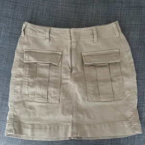 Beige cargo kjol - Kjolen är från Ginatricot å köptes 2020. Den är i storlek 36/S och är i bra skick (använd endast få antal gånger). Du står för frakt (29kr)
