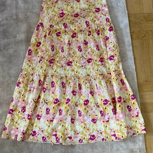 Blommig kjol: Gina Tricot x Maja Nilsson Lindelöf  - Blommig underbar kjol från Gina Tricot, kollektionen av Maja Nilsson Lindelöf. Använd enstaka gånger, i mycket fint skick. Knäpps med ”osynlig” dragkedja. Möts upp i Stockholm eller skickar mot fraktkostnad 