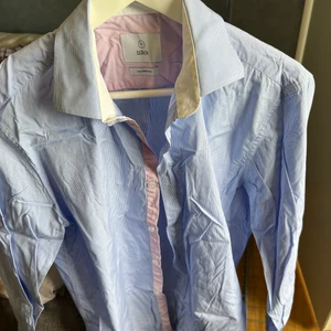 Bläck skjorta - Ljusblå skjorta med rosa detaljer. 