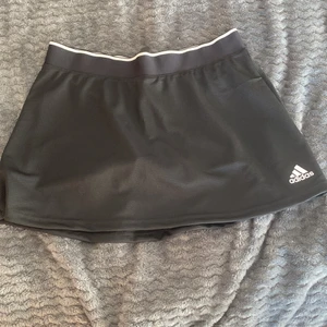 En svart adidas kjol - En svart adidas kjol med inbyggda shorts. Kommer från adidas i storlek M. Aldrig använd lappen är kvar. Äkta!🤟🏻