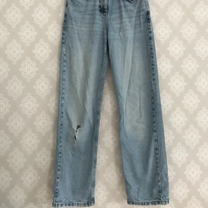 Blå raka jeans med reva - Blå raka / vida jeans med hål / reva på ena "knät". Flitigt använda men i riktigt bra skick ändå💙 Hör av dig om du vill ha fler bilder eller undrar något om storleken!