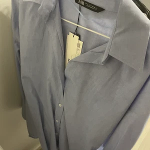 Skjorta zara  - Blå oanvänd skjorta från zara. Köptes för 1 år sedan. Inte använd pga har en liknande. Kom privat för bilder på. Köptes för 259kr . Pris kan alltid diskuteras med mig vid snabb affär. FRI FRAKT 