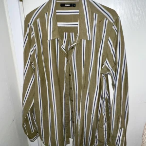  Grön och vit randig skjorta Gina Tricot  - Supermysig vit och grön randig skjorta från Gina tricot🍀 i mycket bra skick (nästan aldrig använd) i storlek L!!!💚💚🥰