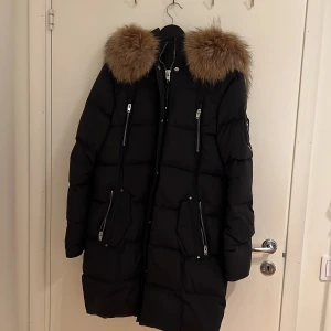 Rock And Blues Arctica jacka - Jackan är i storlek 44, använd en gång då jag inte gillade hur den satt på mig Den är lång och precis som ny!  Den är i äkta päls och fodrad luva