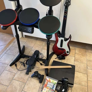Band Hero + ps3 - Band Hero - guitar, - trummor, - mikrofon, - cd skiva (65 låtar), - Playstation 3 + kontroll.  Allting är i fint skick.  Säljer allting tillsammans. Pris: 2800kr  Kolla gärna in mina andra inlägg, Vid intresse av fler varor så fixar jag ett bra paketpris!