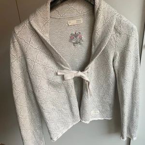 Kofta Odd Molly strl M  - Ljusgrå kofta från Odd Molly med de klassiska banden att knyta ihop.   Djur- och rökfritt hem. Finns i Alingsås och kan skickas mot frakt. Kan även mötas upp i centrala Göteborg enl ök. 