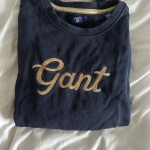 College tröja från gant  - Säljer min UR SNYGGA collage tröja från gant som knappt är använd och är i ett UTMÄRKT skick! Den är marinblå med ett ursnyggt och lyxigt gang märke i guld👌🏼✨