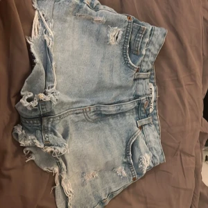 jeans shorts  - jeans shorts stylade med hål. 