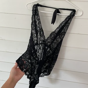 Spetsbody - Snygg body i spets, två rosetter en i fram under bysten och en i bak ovanför rumpan, noga tvättad och använd fåtal gånger!