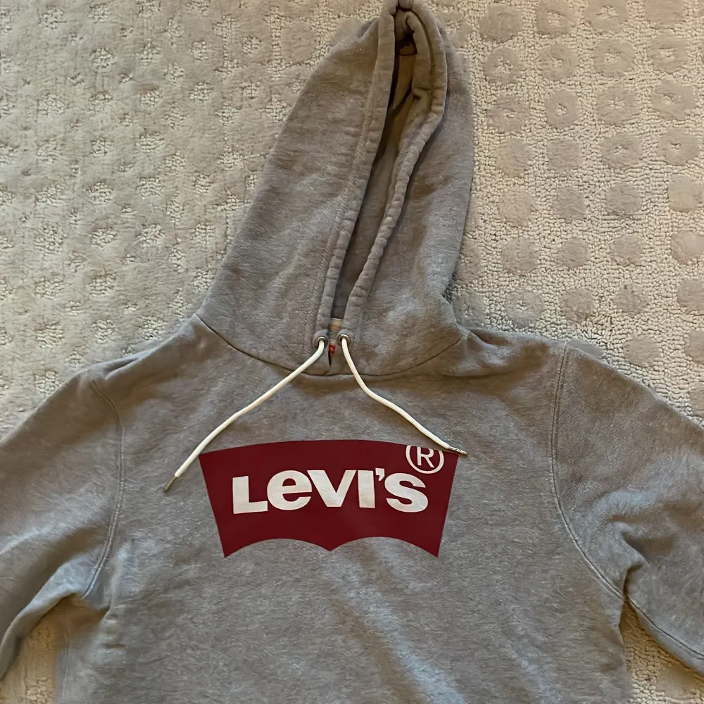 Levis hoodie grå med röd och vit Levis logga. Storlek small. Skön hoodie med lite lösare passform, alltså inte så slim. Nypris 450kr. Bra skick.. Hoodies.