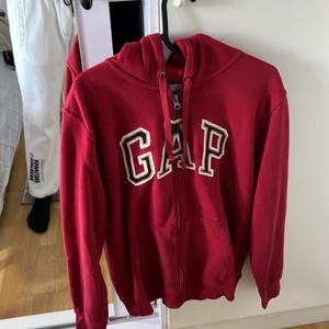 En röd GAP zip hoddie  -  har haft detta plagg i ett halvår o känner att jag inte vill ha den mer den är i väldigt bra sick, det är i storlek S. Köpte den för 400 säljer den för 250kr. Mer frågor, kom privat 