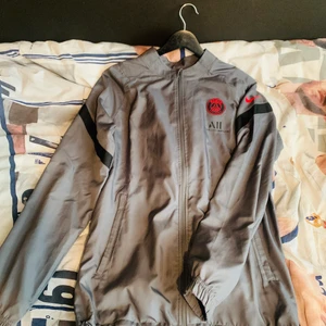 PSG tracksuit grå - En snygg psg tracksiut som e i regn tållande material.Jag säljer denna för att jag vill köpa en annan tracksuit och detta är mest bara för att se om folk är intresserade då sålts den.nypris 1500 mitt pris 1400för att den e knappt använde och är som ny.