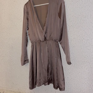 Fin klänning från Nelly, aldrig använd🧚🏼‍♂️🧚🏼‍♂️ - Nyskick, fin och elegant klänning med glansigt material 💗🤍