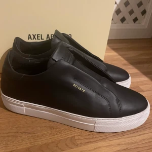 Axel arigato skor  - Säljer nu arigato skorna då dom var i fel storlek för mig. Storlek 44. Skorna är använda 1 gång, så dom är typ helt nya.  Box, dustbag och kvitto finns! 