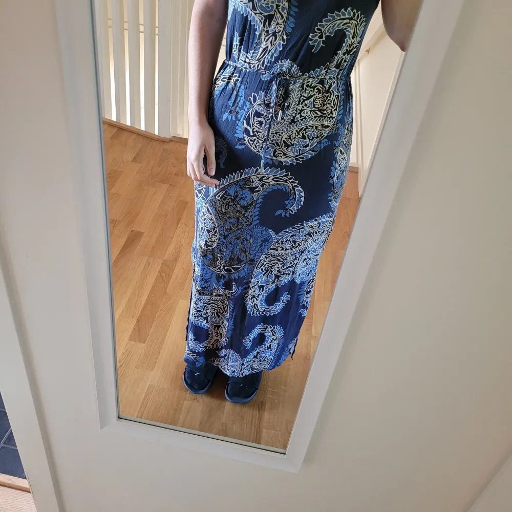 Fin skön lång blå klänning med mönster . Jag har endast använt den en gång då den inte riktigt min stil. Minns ej var jag köpte den men står Part Two Copenhagen på lappen. . Klänningar.