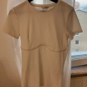 Only- vit T-shirt med en markerad sömn under bysten - Har inte kommit till användning 