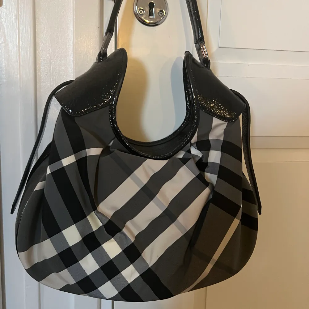 En mönstrad (grå, vit, svart) BURBERRY handväska. Mellanstor. Den är ÄKTA. . Väskor.