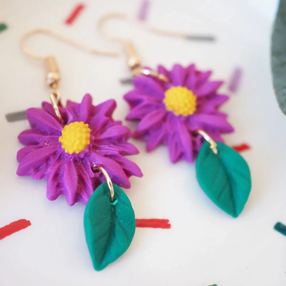 Purple flower with leaf earrings, simple, colourful and super cute, will bring up your day :).    The earring are handmade by me with love and always fresh bake, come out from my oven. The earrings are made from polymer clay, I use both Fimo and Cernit clay. They might have slight variances, every piece is unique. . Accessoarer.