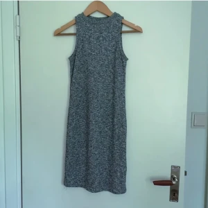 Atmosphere klänning strl 38 - Stickad kort klänning i grå-svart tråd. Fin kvalité på tyget, lite stretchigt. 