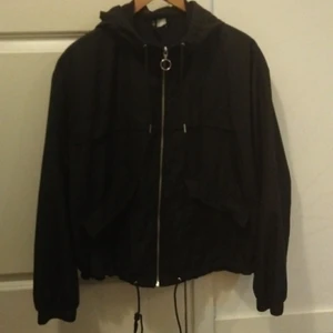 Vårjacka - Svart tunn jacka kommer ifrån H&M. Storleken är L och använd några enstaka gånger så den är som ny. Fickor med knapp. Frakt ingår inte i priset. 