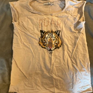 Barn t-shirt med tryck - Barn t-shirt med tryck på ett lejon och text ”roar”, oanvänd.