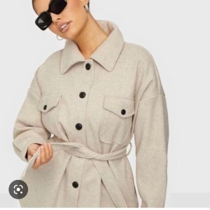 Kappa - Beige kappa från Nelly. Köpt för 699kr, använd max tre gånger 