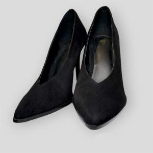 Court shoes in soft suede with pointed toes and covered heels. Linings in satin made from recycled polyester, and leather insoles. Heel 7 cm.  