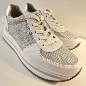Mikael Kors Monique Sneakers - Super fräscha vita och silvriga sneakers från Mikael Kors (serien Monique). Bara använda en gång inomhus så är i nyskick! Perfekt till våren. Säljes inte heller längre så passa på!  Super förtjust i dem men p.g.a. fel storlek så säljer jag dem. 