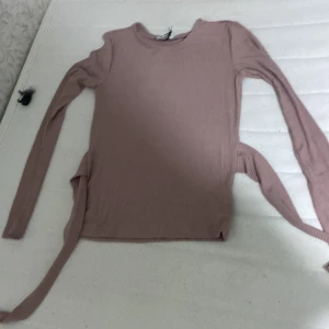Lila tröja  - EEG man kan knyta där bak och den är ny aldrig använt lappen är kvar
