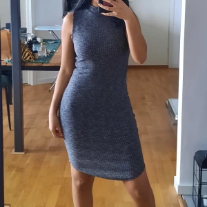 Ribbad långklänning  - En tajt ribbad klänning med turtleneck. Säljer den då det inte är min stil.