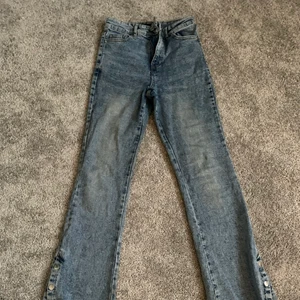 Ljusblåa jeans  - Ljusblå jeans som har tre knappar längst ner och går att knäppa upp.