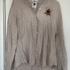 LinneSkjorta Dam - Linneskjorta med Falsterbo Horse Show Märke. Storlek 36. Går ej att köpa längre, limited edition :) Väldigt fint skick!