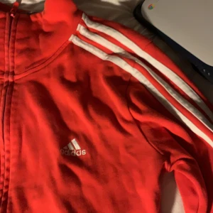 Adidas zip up tröja - Hej!! Säljer min favvo kofta från adidas  eftersom att jag inte använder den lika mycket,  ”den är lite mer rödare i verkligheten❤️❤️❤️” skriv gärna ifall du har några funderingar❤️‍🔥❤️‍🔥