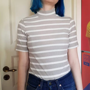 Grå randig top - Grå och vit randig ribbad tröja, med polokrage och korta ärmar.