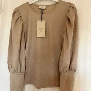 Beige Topp med Ballongärm - Fin långärmad tröja med ballongärmar från Free/Quent😍.  Aldrig använd då den är lite stor på mig!