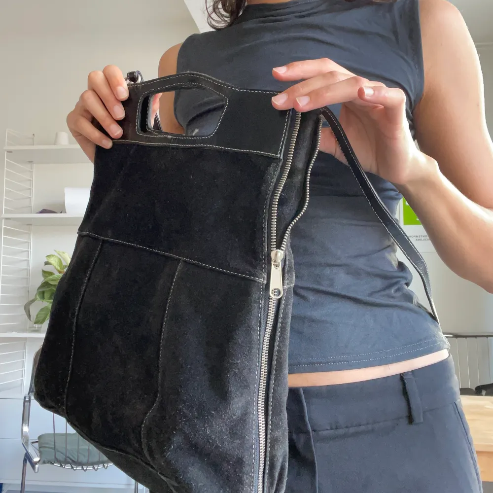 Superfin svart mocka (lite grå ton) går att bära i handtag eller över axeln. Dragkedjan går att dra ner vilket gör väskan större. Väskor.