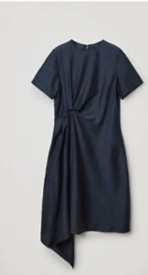 Skimmrande klänning från COS storlek 40 - Är en stor 40a, liten 42a. Behöver strykas. Använd en gång så fint skick. Mörkblå färg som skimmrar