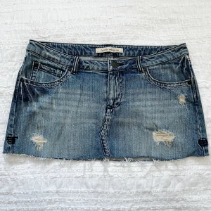 Jeanskjol kjol  - Använd ett fåtal gånger och i bra skick. Storlek: saknas. Passar nog 27-29. Midjemått 82 cm, framsidans längd 24 cm, baksidans längd 30 cm.