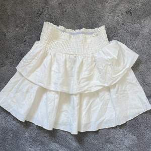 En vit volang kjol perfekt nu till sommaren, den är i något liknade linne matrial och sitter super fint