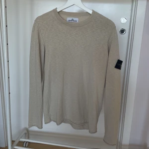 Stone Island finstickad tröja - Beige finstickad tröja från Stone Island i herrstorlek M. Nypris runt 3500kr, säljes för 1300kr. Köpt på NK i Göteborg, kvitto finns!