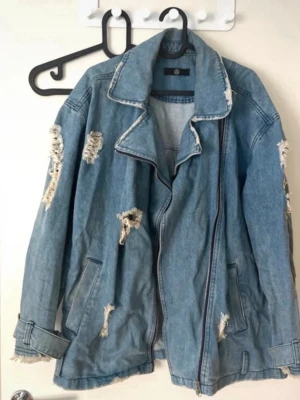 Oversized jeansjacka i biker-modell med slitningar, strl M - Säljer denna snygga jeansjacka från Missguided.  Slitningarna ger en snygg vintage känsla, medan passformen ger en kaxig bikerlook. Rymlig passformen är rymlig. Mycket fint skick ⚡️⚡️