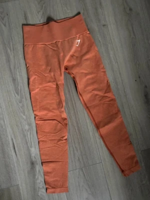 Orangea gymshark tights  - Använda men av riktigt bra kvalité så därför i väldigt bra skick.