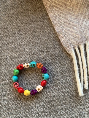 Färgglatt armband med döskallepärlor - Coolt armband med pärlor formade som döskallar i olika färger som röd, blå, grön, gul, lila, orange och vit. Perfekt för dig som gillar unika och färgstarka accessoarer.