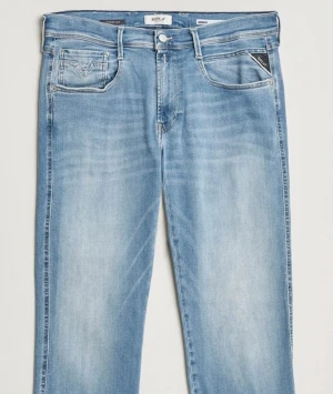  Replay Jeans - Säljer ett par ljusblå jeans från Replay med klassisk femficksdesign och snygga slitningar. Jeansen har en rak passform och är tillverkade i mjukt denim tyg. Strl 29/32.