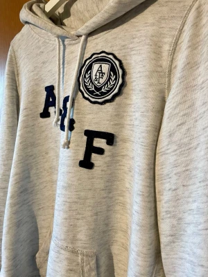 Abercrombie & Fitch hoodie - Märke: Abercrombie & Fitch | Passform: Slim/Regular | Storlek: M | Färg: Grå | Skick: 8/10 | Defekter: Inga. Kom gärna med frågor!