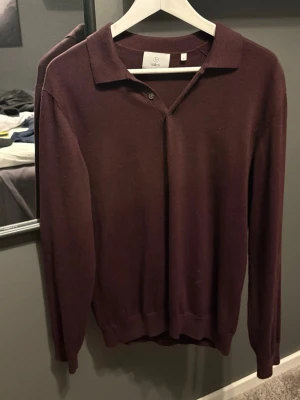 Vinröd pikétröja från Bläck - Snygg vinröd långärmad pikétröja från Bläck med klassisk krage och knappdetalj vid halsen. Endast testad. Storlek M. Skriv vid frågor eller funderingar!