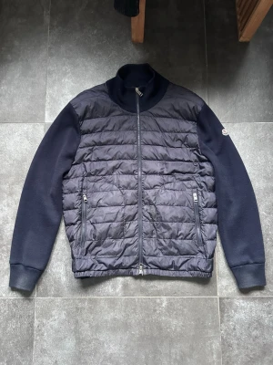 Moncler cardigan - Säljer nu denna moncler cardigan i rätt bra skick, se bilder. St XXL men kan också passa XL. Hål vid båda ärmsluten men inget som påverkar när man bär den. Bedöm skick själv utifrån bilderna.