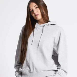 Ljusgrå hoodie med huva - Säljer en stilren ljusgrå hoodie med klassisk huva och dragsnören. Hoodien har en avslappnad passform, ribbade muddar vid ärmslut och midja samt är tillverkad i mjukt sweatshirtmaterial. Perfekt för en chill och bekväm look.