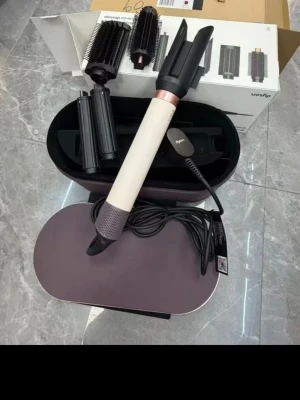 Dyson Airwrap multistyler set - Säljer ett Dyson Airwrap multistyler set i lila och vitt med flera utbytbara tillbehör för hårstyling. Setet kommer i en snygg oval förvaringsväska i matchande färg. Perfekt för att skapa lockar, volym eller slätt hår med avancerad teknik.