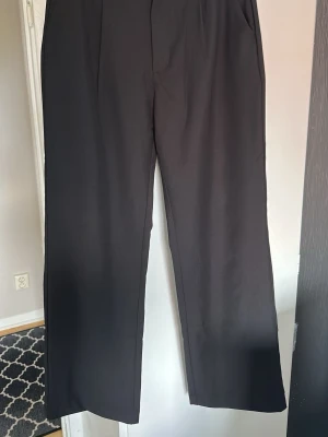 Svarta vida kostymbyxor  - Snygga svarta kostymbyxor med rak och vid passform från Lager157. Byxorna har hög midja och klassisk design utan synliga detaljer framtill. I mycket bra skick. Sitter jättefint på 🌸